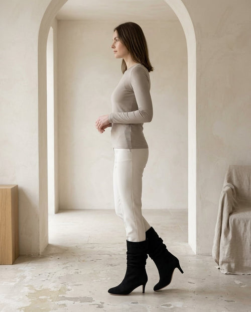 Black mid-calf boots on model, side profile | Maison Perigee — side
